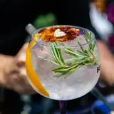 Ein erfrischender Gin Tonic mit Rosmarin und karamellisierter Orangenscheibe, einer der besten Gin Cocktails.