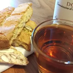 Cantuccini mit Mandeln und ein Glas süßer Dessertwein aus der Toskana, perfekt für einen Genussmoment.