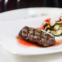 Saftiges Rinderfilet mit gegrilltem Gemüse und einer köstlichen Portweinsauce, garniert mit Rosmarin.
