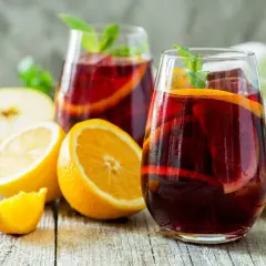 Erfrischender Sangria mit Orangen- und Zitronenscheiben, Minze und Eis. Das beste Sangria Rezept für heiße Tage.