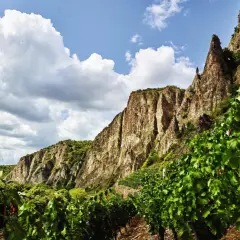 Steile Weinberge am Felsen, die auf die besten Naheweine hoffen lassen. Wolken ziehen über die beeindruckende Landschaft.