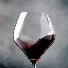 Ein Glas Rotwein wirbelt, erinnert an die tiefen Aromen von Navarra, Spanien.