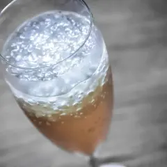 Ein prickelnder Champagner-Cocktail mit feinem Schaum und Bläschen in einem eleganten Glas.