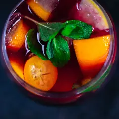 Erfrischender Sangria mit Orangen-, Zitronen- und Kumquat-Scheiben sowie Minze. Die Zutaten Sangria sind perfekt für einen heißen Sommertag.