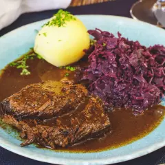 Rinderbraten in dunkler Sauce mit Klößen und Rotkohl. Ein guter Rotwein zum Kochen Rinderbraten macht dieses Gericht perfekt.