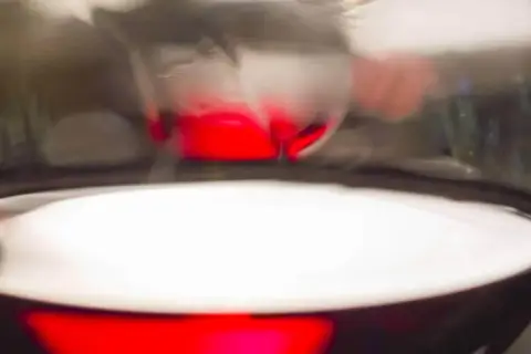 Ein Glas mit tiefrotem Wein, das als Rotwein-Ersatz für ein Gericht dient.