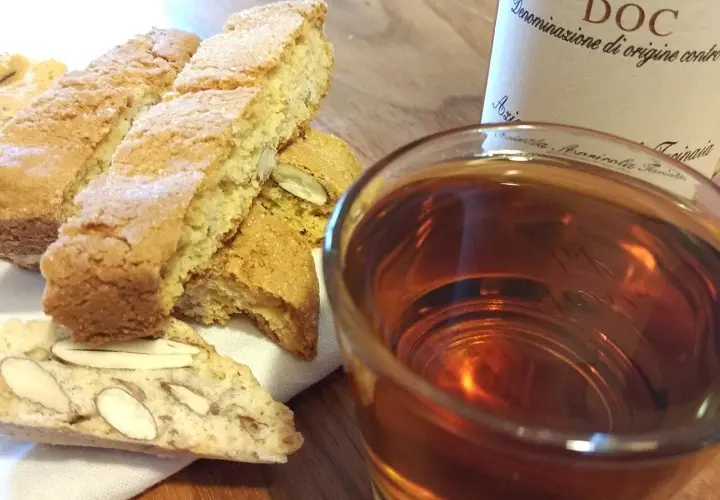 Cantuccini mit Mandeln und ein Glas süßer Dessertwein aus der Toskana, perfekt für einen Genussmoment.
