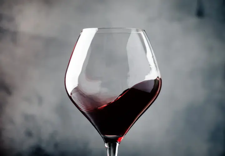 Ein Glas Rotwein wirbelt, erinnert an die tiefen Aromen von Navarra, Spanien.