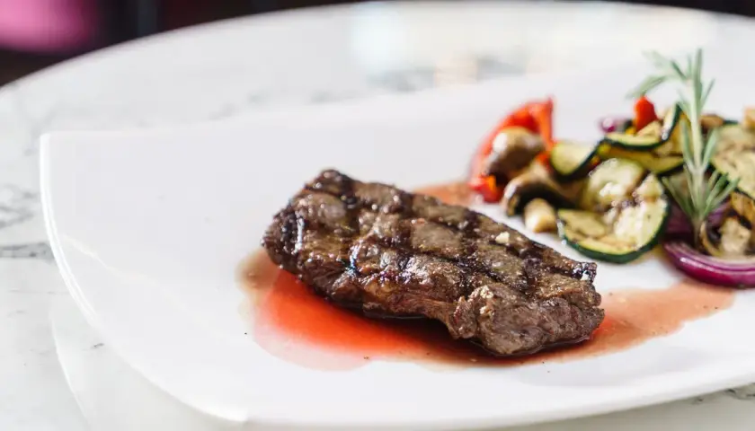 Saftiges Rinderfilet mit gegrilltem Gemüse und einer köstlichen Portweinsauce, garniert mit Rosmarin.