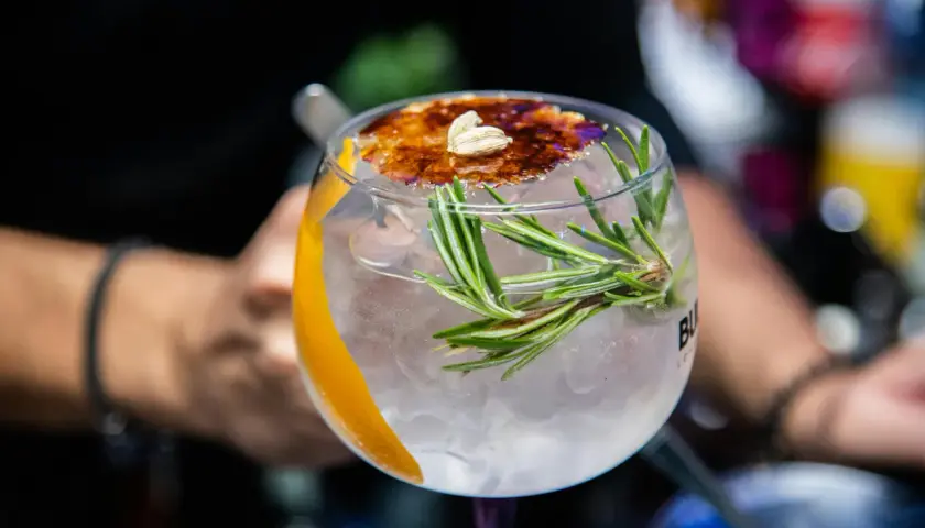 Ein erfrischender Gin Tonic mit Rosmarin und karamellisierter Orangenscheibe, einer der besten Gin Cocktails.