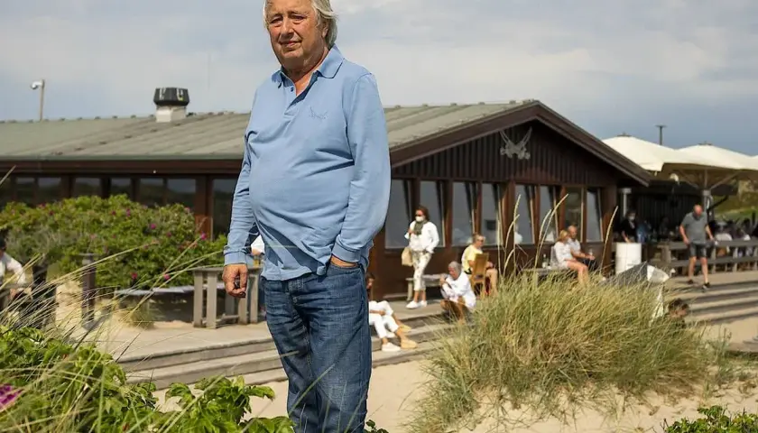Herbert Seckler steht am Strand vor einem Restaurant.