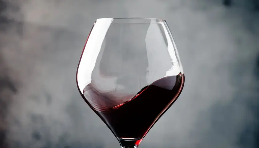 Ein Glas Rotwein wirbelt, erinnert an die tiefen Aromen von Navarra, Spanien.
