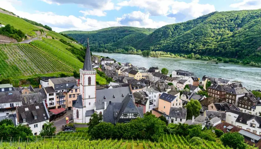 Dorf am Fluss mit Weinbergen und Kirche, Deutschland.