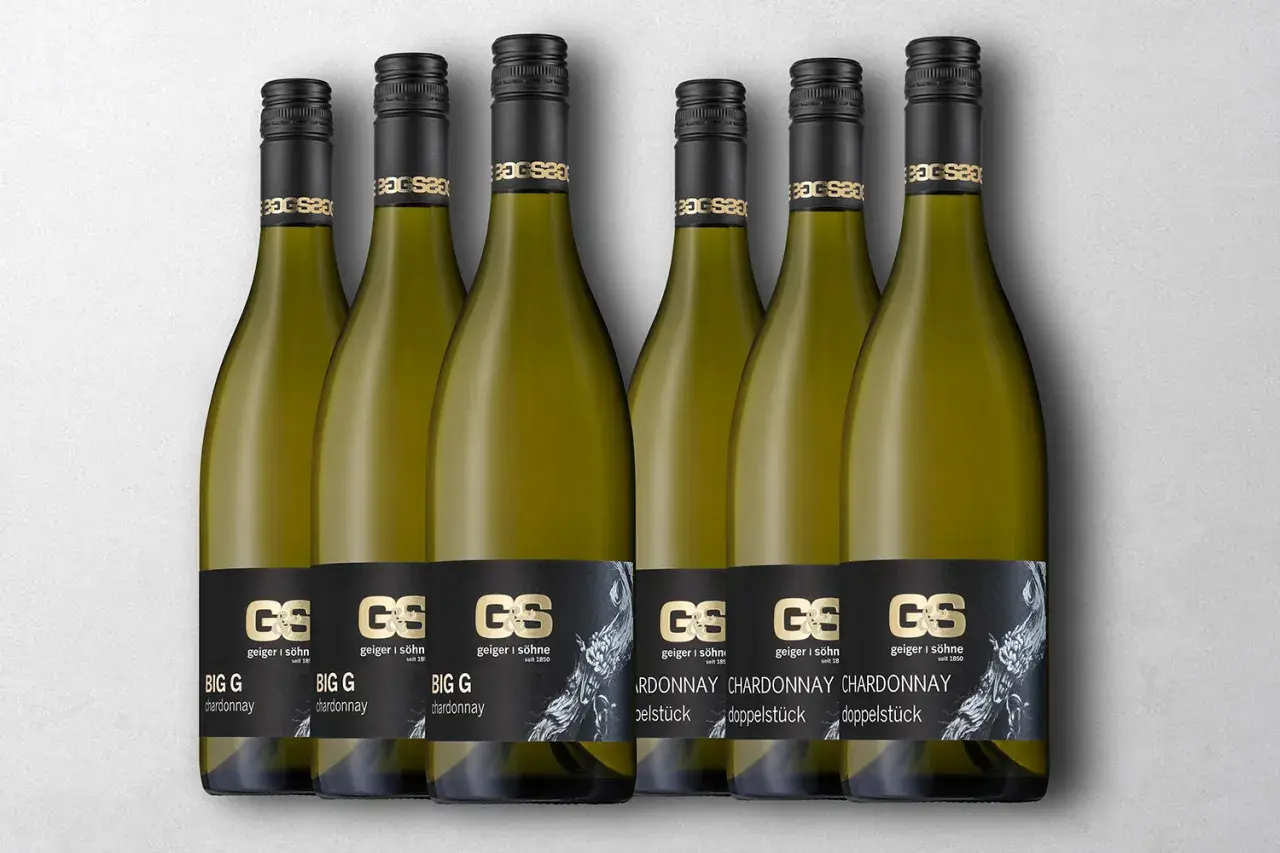 Sechs Flaschen Chardonnay von "BIG G" im Vergleich zu Pinot Grigio. Elegante goldene Etiketten auf schwarzem Grund.
