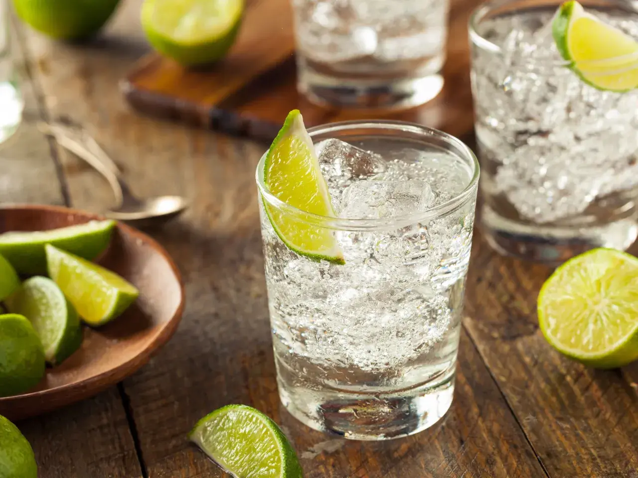 Erfrischende Cocktails mit Gin und Limette, serviert auf rustikalem Holz.