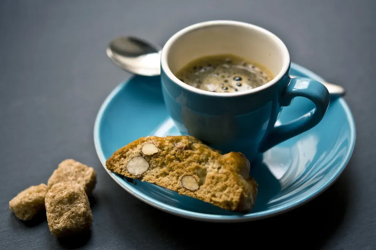 Ein Espresso mit Cantuccini und braunem Zucker, perfekt zum Genießen eines italienischen Dessertweins.