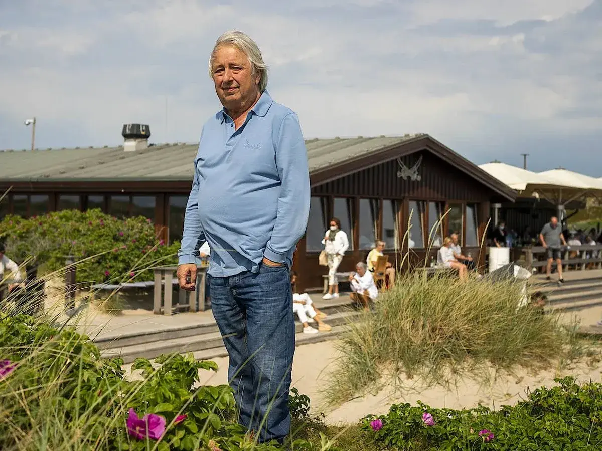 Herbert Seckler steht am Strand vor einem Restaurant.
