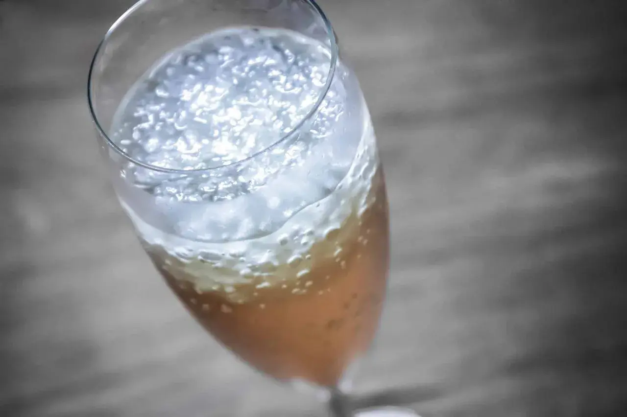 Ein prickelnder Champagner-Cocktail mit feinem Schaum und Bläschen in einem eleganten Glas.